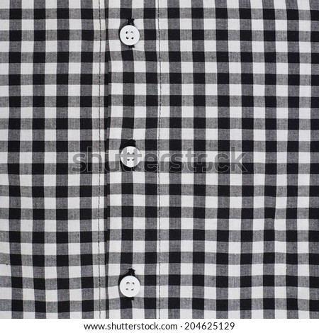 Fragment of a squared black and white shirt cloth fabric with the buttons as a background texture