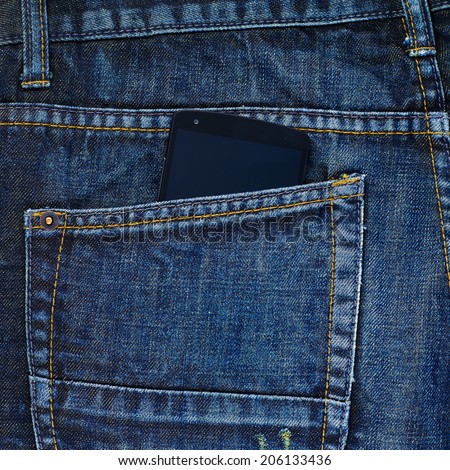 Black smart phone in a back pocket of a navy blue denim jeans as a background composition