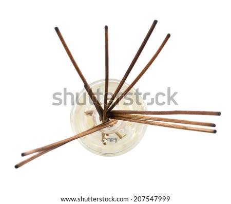Wooden aroma sticks in a glass flask filled with flavor liquid substance isolated over white background, top view