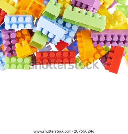 Pile of colorful plastic toy construction bricks isolated over the white as a copyspace background composition