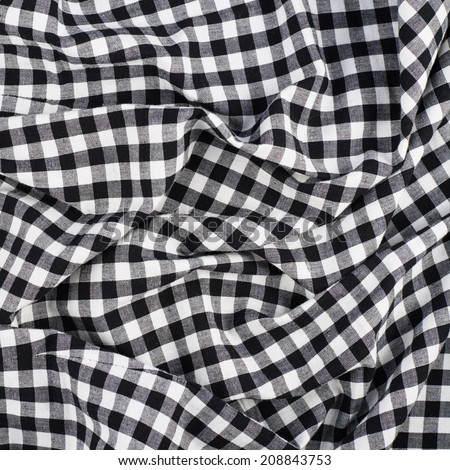Fragment of a wrinkled squared black and white shirt cloth fabric as a background texture