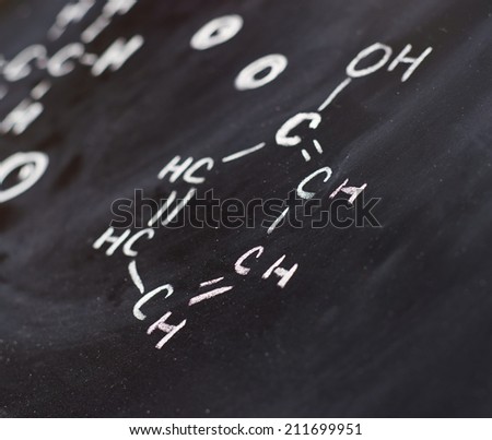 Blackboard with some chemistry structures drawn with chalk as a background composition with a shallow depth of field