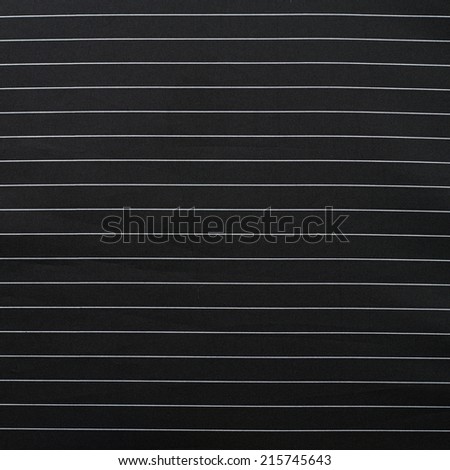 Black cloth material with the white thin stripes fragment as a background texture composition