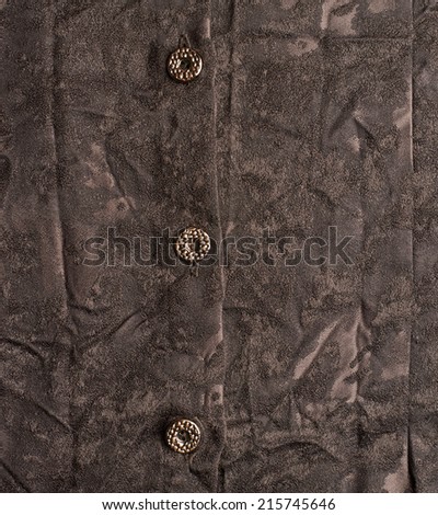 Creased brown cloth material fragment with the buttons as a background texture composition