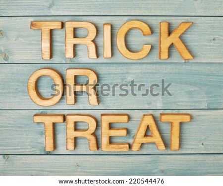 Trick or treat written with wooden letters over the covered with green boards surface composition