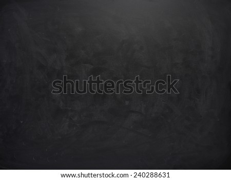 Black board with the traces of chalk over its surface as a background texture