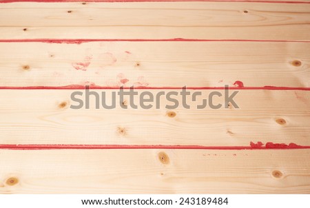 Surface covered with multiple pine wood boards with the paint stains and leaks in the gaps, as an abstract background composition