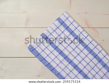 Blue squared tablecloth or towel over the surface of a wooden table