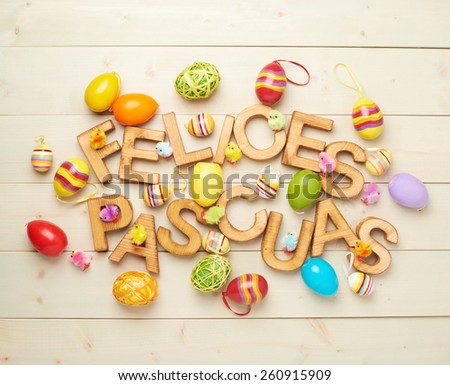 Words Felices Pascuas as Happy Easter in spanish language made of wooden letters and surrounded with multiple egg decorations as a festive Easter background composition