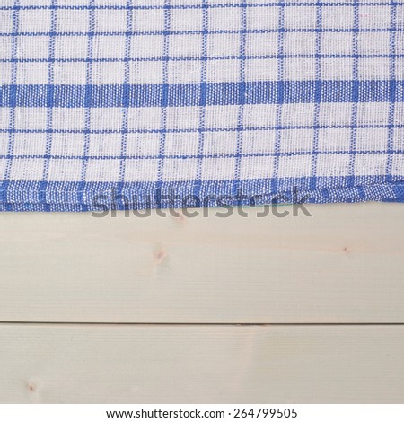 Blue squared tablecloth or towel over the surface of a wooden table