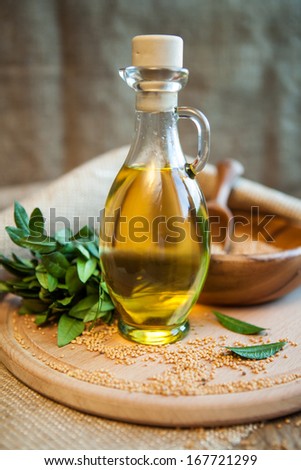 mustard oil in a vessel with seeds on a wooden background