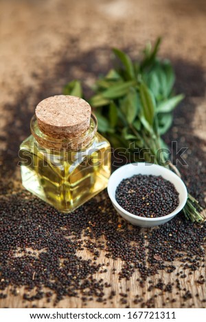 raps oil in a vessel with seeds on a wooden background
