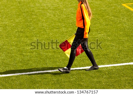 Female soccer referee hold the flag during a match