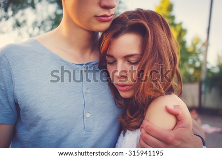 Sad woman hugging her boyfriend and looking down couple problems concept