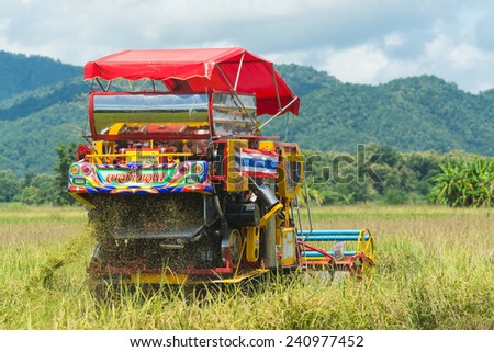 Sukhothai,THAILAND-2014 November 27:The tradition farmer use machine harvesting rice on the farm filed.