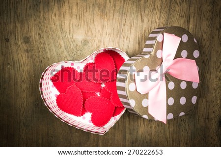 Open gift box with lots of cute little hearts inside. On old wood background.