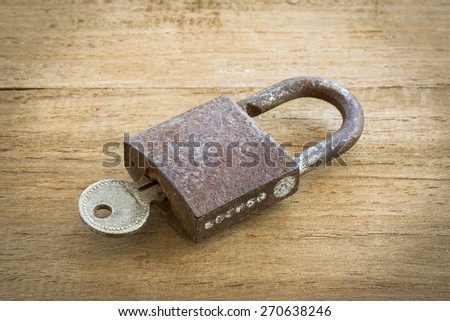 Big old rusty open padlock,focus at lock,padlock on wooden background