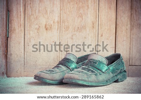 Dirty old leather shoes on wooden background.