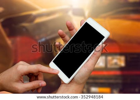 woman hand hold and touch smart phone,cell phone,mobile over blurred image of broken car : calling mechanic service from repair shop and insurance concept