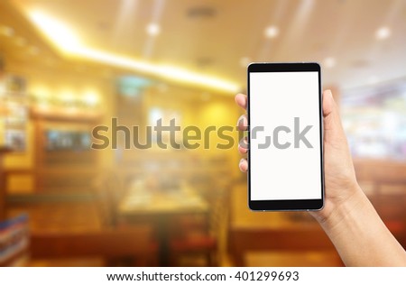 woman hand holding,using and touch smart phone,cell phone,mobile over blurred image of restaurant background,Transactions by smartphone concept