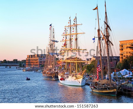 BAY CITY, MICHIGAN-JULY 11, 2013: Tall Ships line the river\'s edge at Wenonah Park at sunset for the Tall Ship Celebration