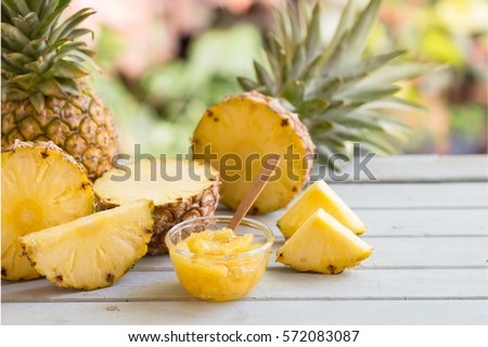 Homemade pineapple jam in glass bowl and pineapple slice with copy space