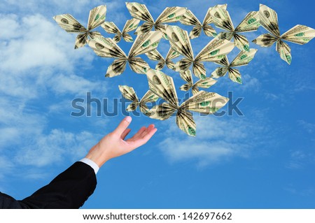 business man hand release origami butterfly from 100 dollar bill