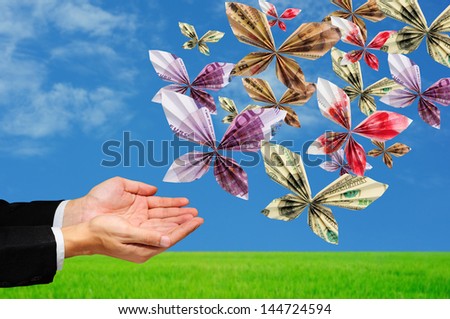 hands releasing origami butterfly made from mix banknotes