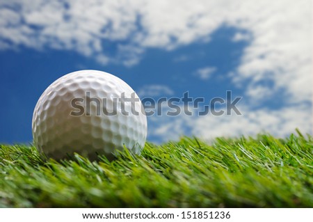 golf ball on grass with blue sky