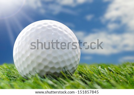 golf ball on grass with blue sky