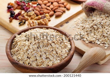 rolled oats in wooden bowl and muesli ingredients
