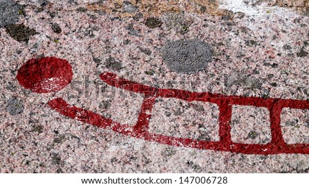 Detail of a Scandinavian stone carving of a ship and a cup mark. Rock carvings called petroglyphs depicting old ritual patterns of ships and stars and were created from the bronze age to the iron age