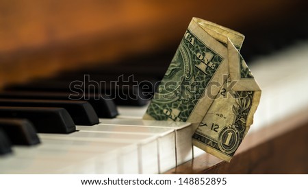 Dirty old one dollar bill stuck in a piano.- Hard times being a musician