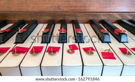 Thumbtack on piano keys making it difficult or painful to play music.  \