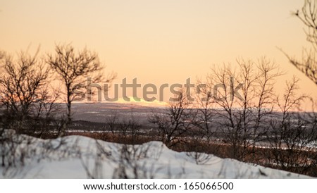 Arctic mountain landscape on yellow sky