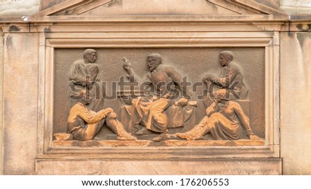 Art Deco inspired classical relief of a teacher or story teller sitting next to a globe surrounded with pupils