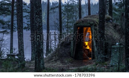 Cozy burrow like shelter in Sweden, the lake behind is iced
