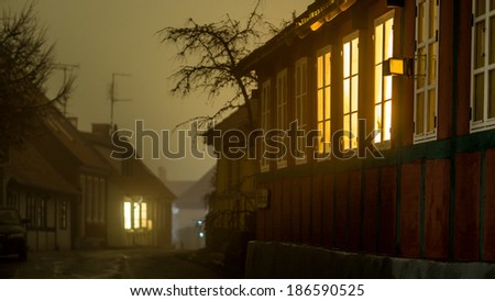 Light shining from windows in fog in a old danish town Sandvig on the island of Bornholm