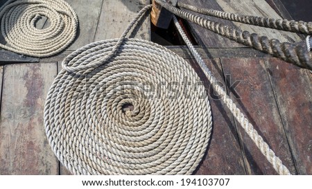 Curled up tarred hemp rope on viking ship deck