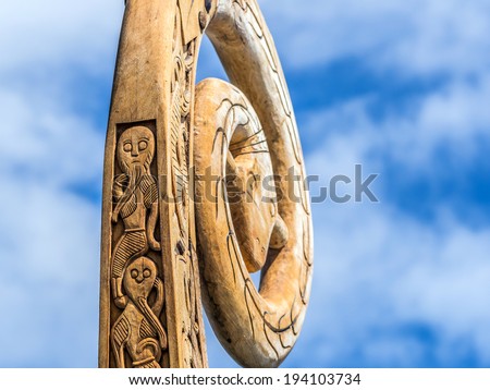 Viking ship wood carving ornaments featuring a bearded men and in the backgound a \