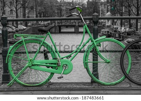 Green bike isolated on black and white over an Amsterdam canal.
