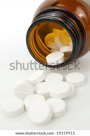 Pills spilling from bottle (shallow DOF)
