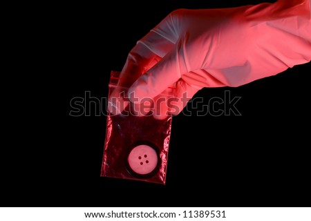 Hand in glove holding the evidence, isolated on black background