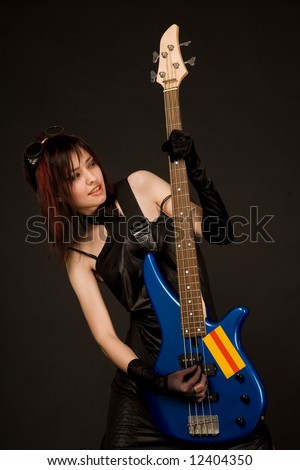 Beautiful girl playing bass guitar isolated in studio