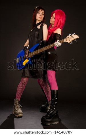 Two rock girls with bass guitar, isolated on black background