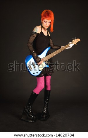Rock girl with bass guitar isolated on black background