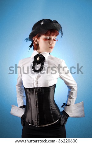 Beautiful girl in Victorian style clothes, studio shot over blue background