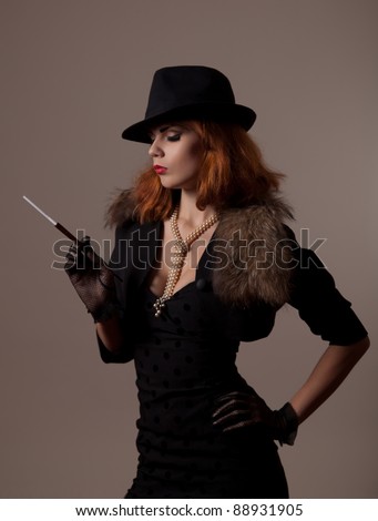 Gangster woman in fedora hat and evening dress holding mouthpiece