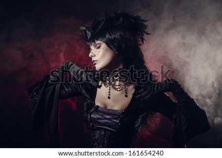 Romantic gothic girl in Victorian style clothes, shot over smoky background