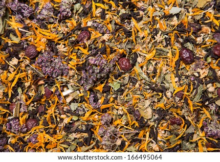 Texture of healthy herbal tea with yellow flowers and red berries